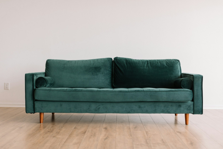 Cozy boho-styled small apartment living room with warm neutral tones, decorative plants, macrame wall art, woven baskets, and fairy lights